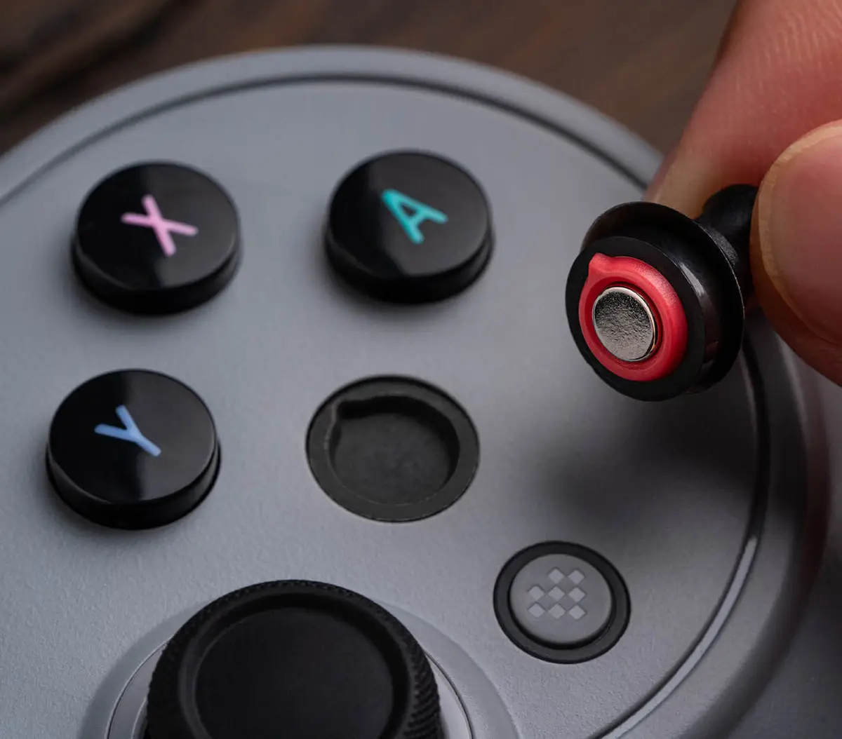 Fingers swapping a magnetic ABXY button on the Pro 3