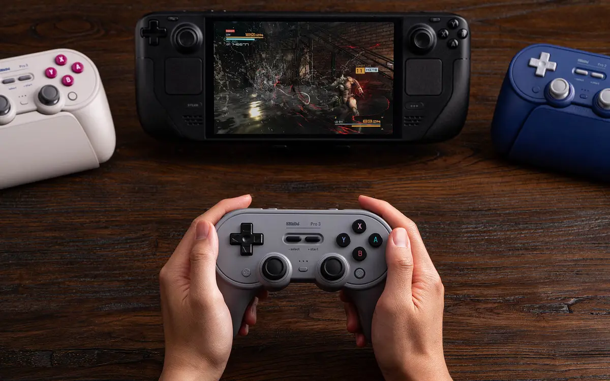 Gray Pro 3 controller held in front of a handheld PC playing a game