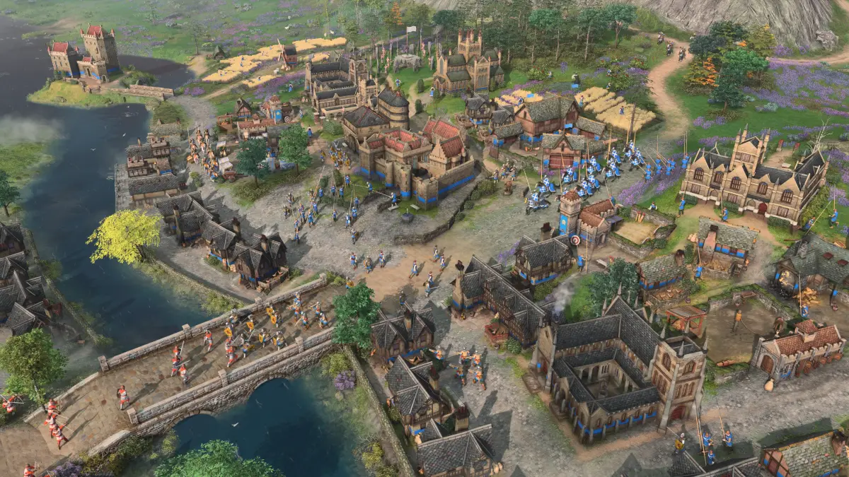 A Scottish town with a stone bridge and troops crossing it in Age of Empires IV