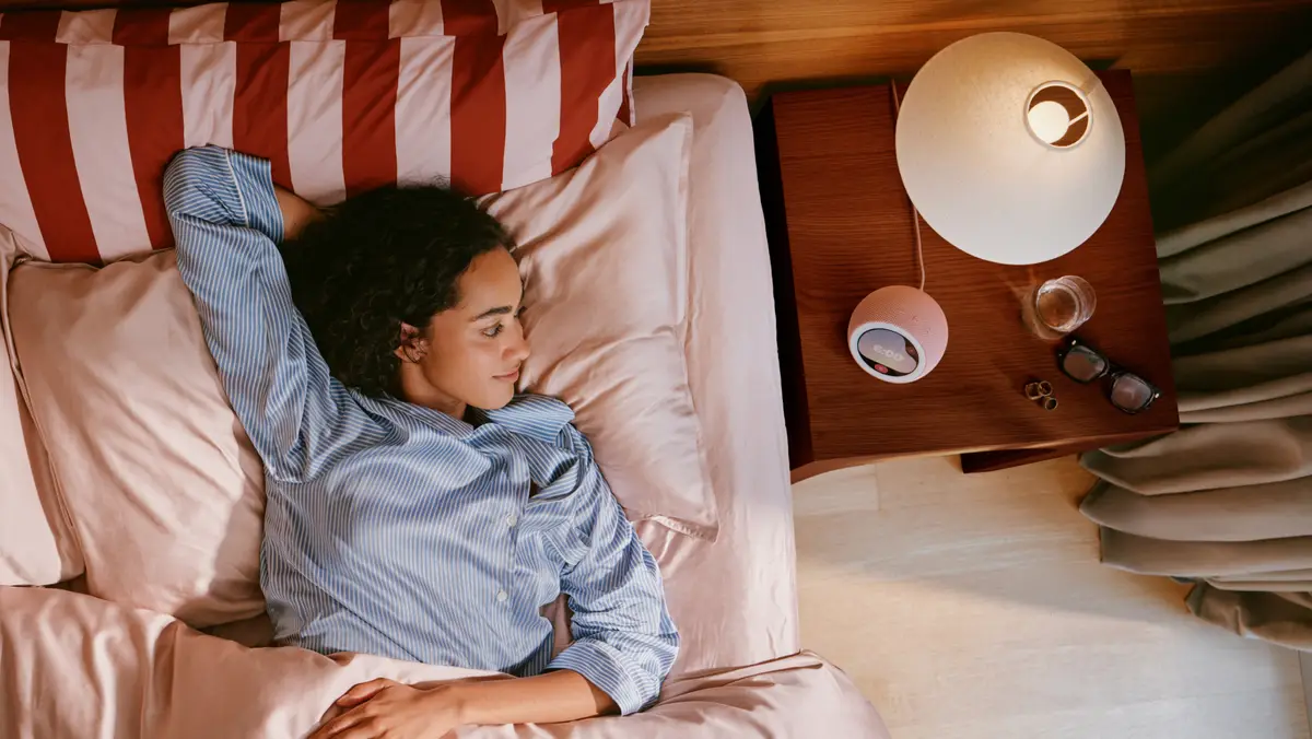 Person asleep in bed with an Echo Time clock on the bedside table