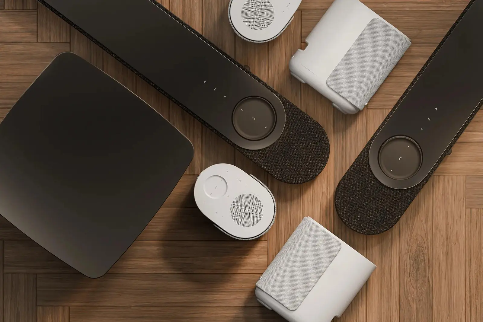 木の床に並んだ黒と白のBose Lifestyle Ultraサウンドバー、サブウーファー、スピーカー
