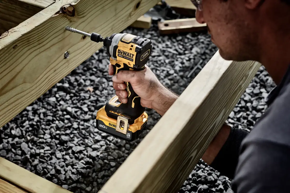 ਇੱਕ ਮਿਸਤਰੀ ਡੈੱਕ ਦੇ ਢਾਂਚੇ ਉੱਤੇ DEWALT ATOMIC ਇੰਪੈਕਟ ਡਰਾਈਵਰ ਵਰਤ ਰਿਹਾ ਹੈ