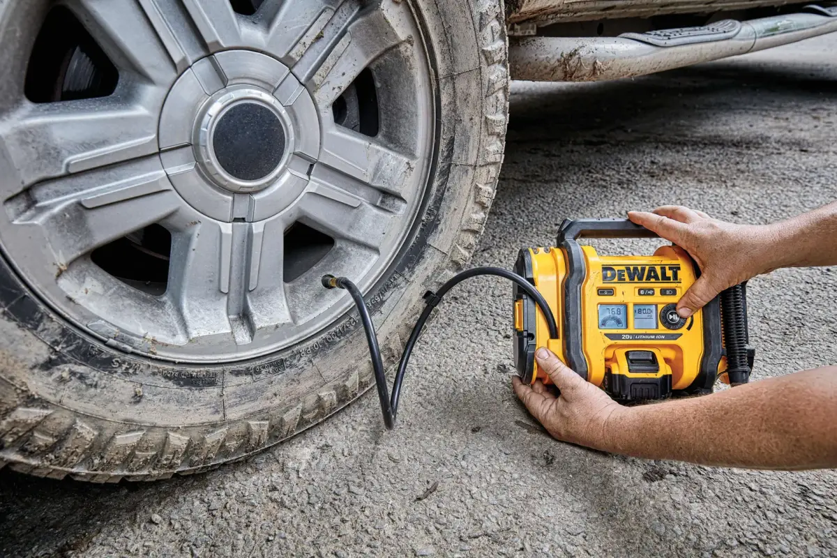DEWALT DCC020IB inflator being held against a truck tire