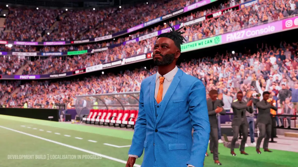 Football Manager 27 manager in a blue suit walking along the touchline in a packed stadium