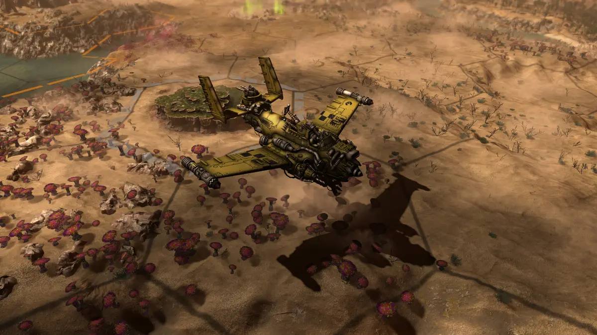 A yellow and green ground attack aircraft casting a shadow over desert terrain