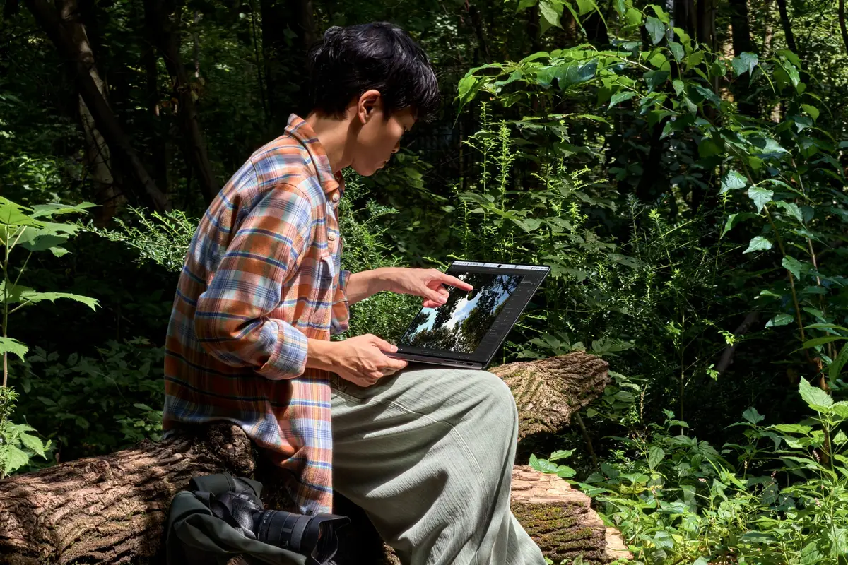 A person working on the MacBook Pro outdoors in bright light