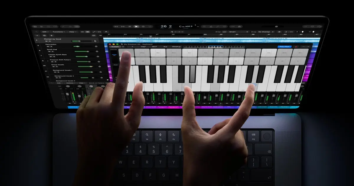 Hands playing a software piano on the touch screen of the new MacBook Pro