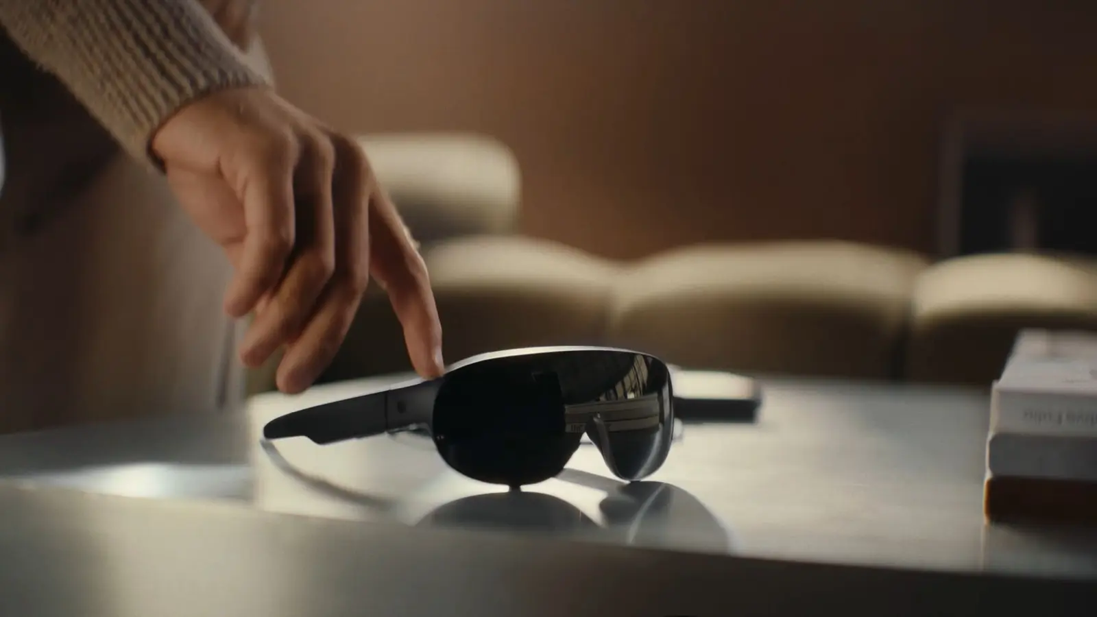 Meta VR Glasses resting on a table as a hand reaches toward them