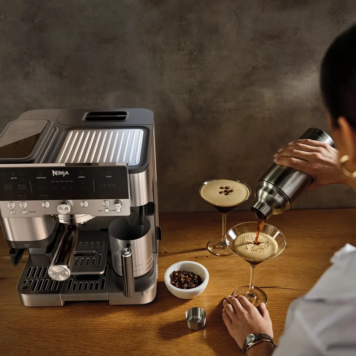 Person shaking an espresso martini next to the machine
