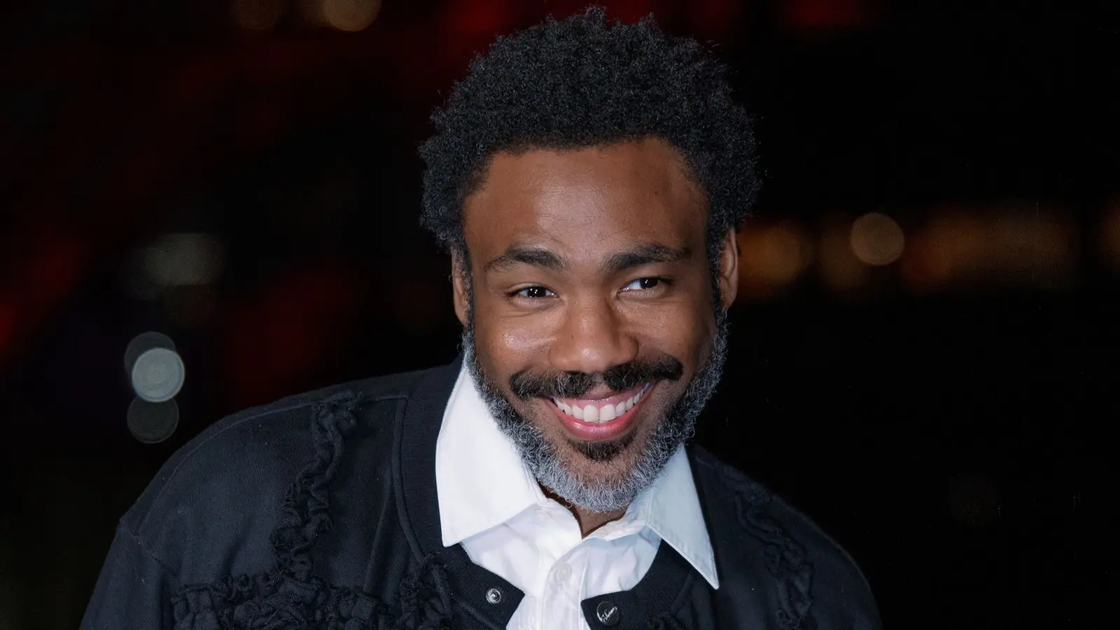Donald Glover smiling at an evening event