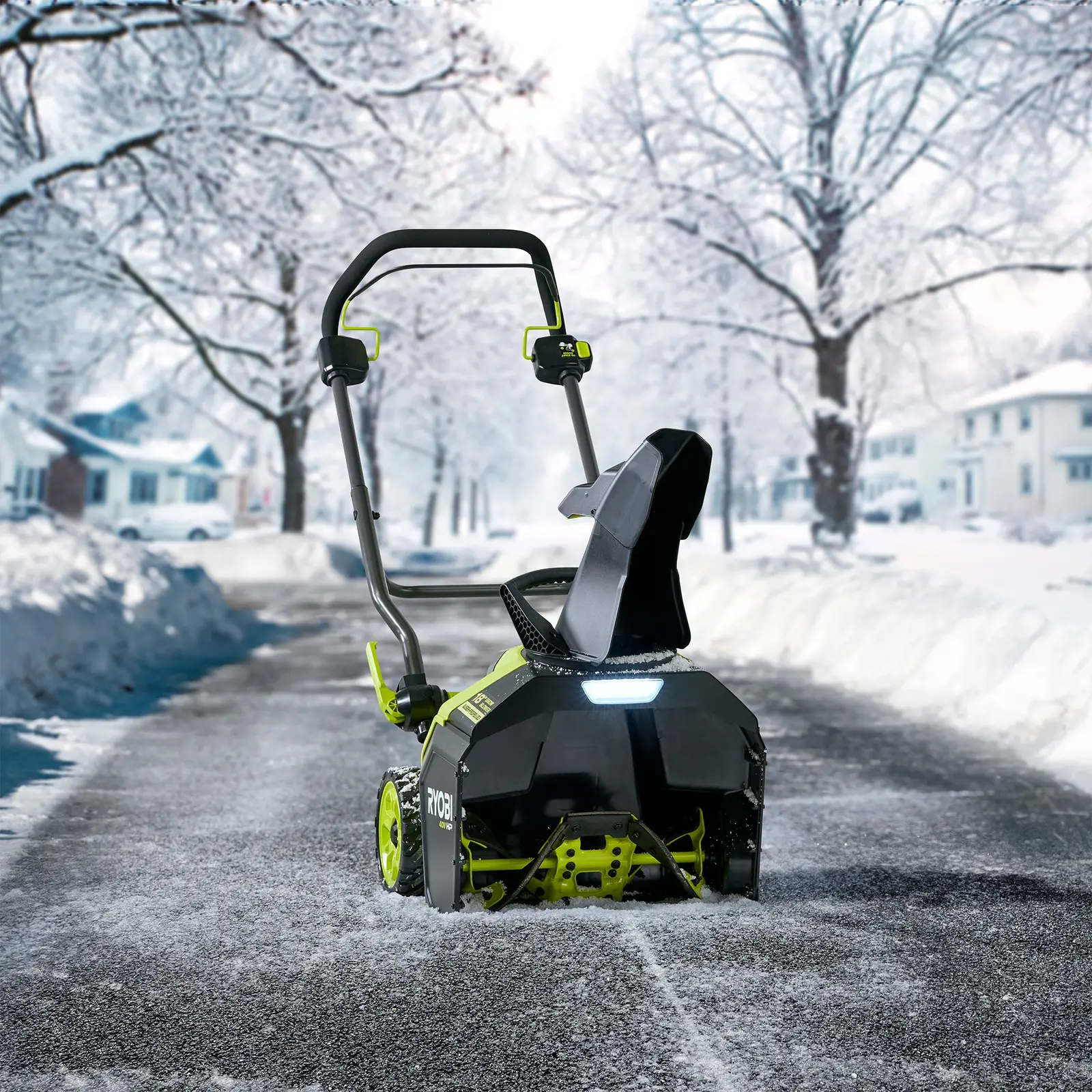 A Ryobi 40V HP cordless snow blower on a snowy residential street