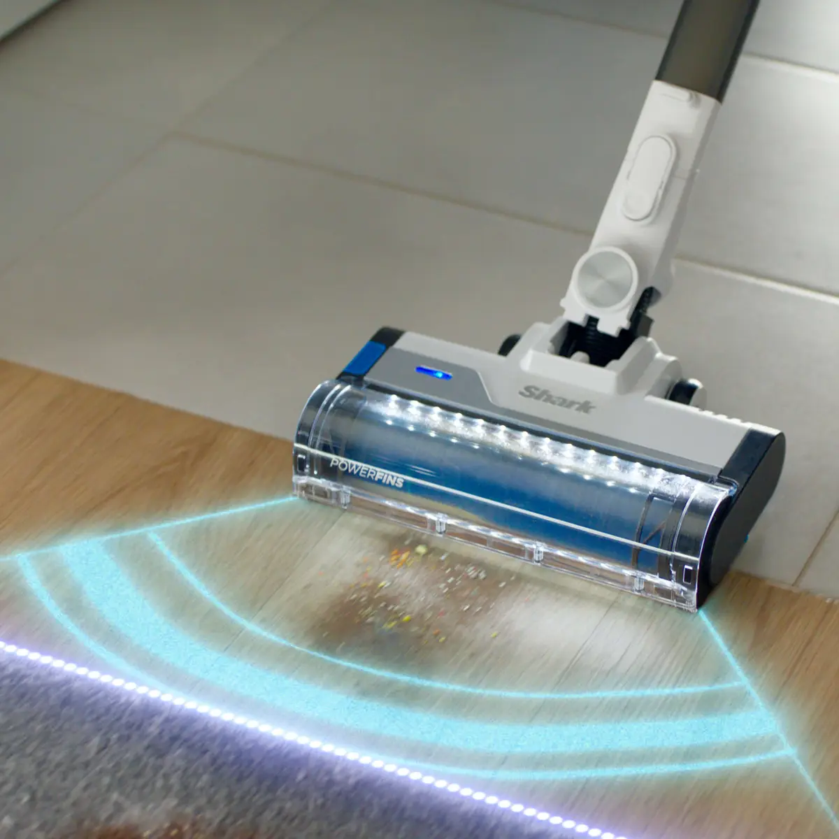 Close up of the PowerFins nozzle with floor sensing light effect on a wood floor