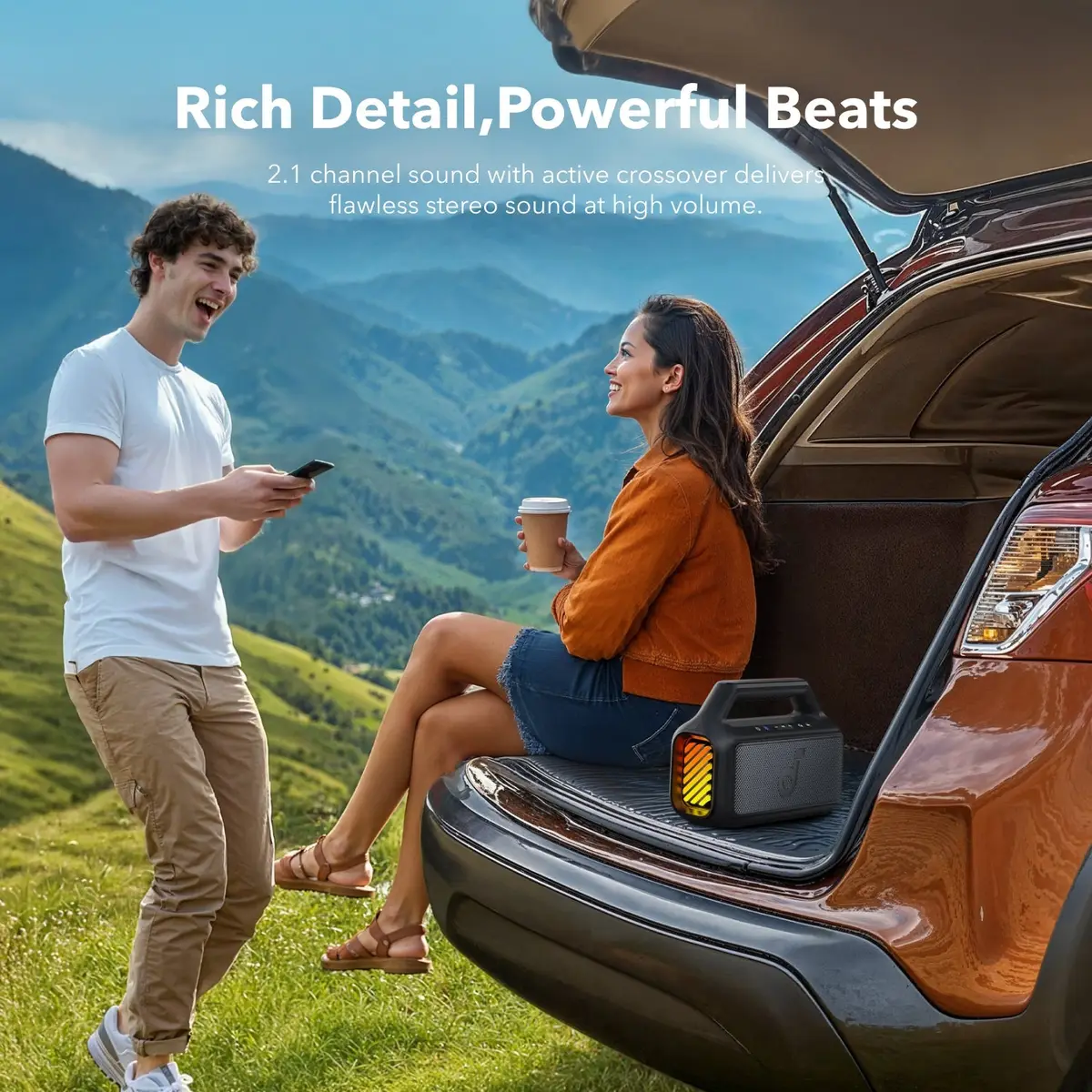 Two friends listening to the Boom 2 at the back of an SUV in the mountains