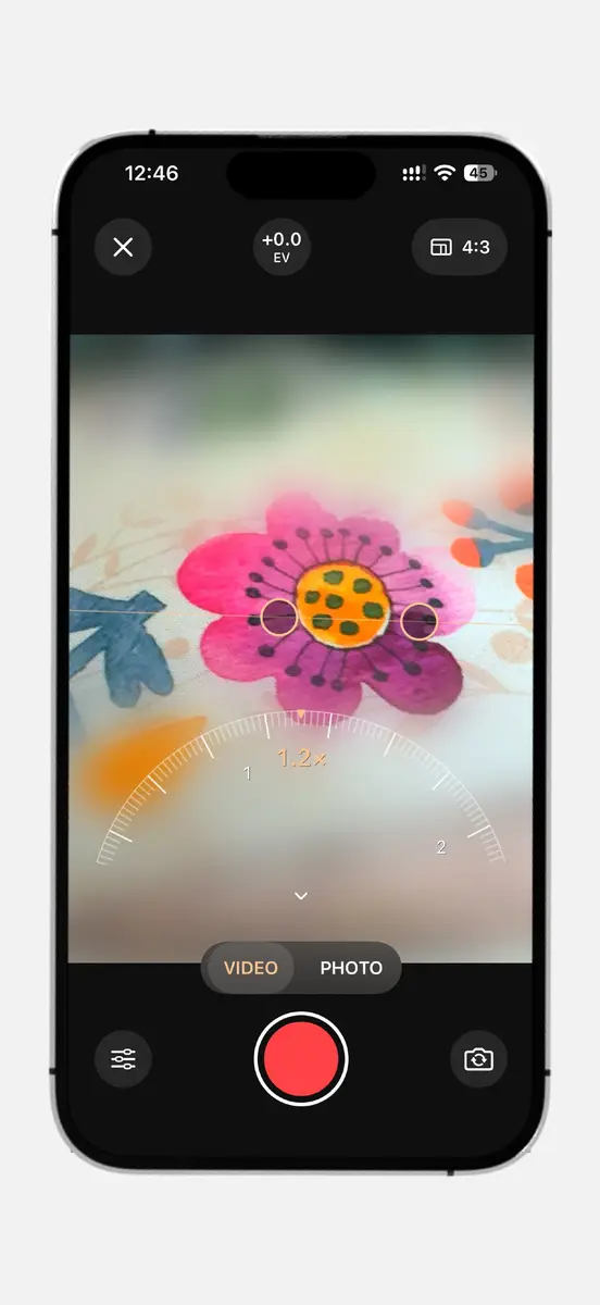 Camera in video mode showing a flower with a blurred miniature effect and a zoom dial