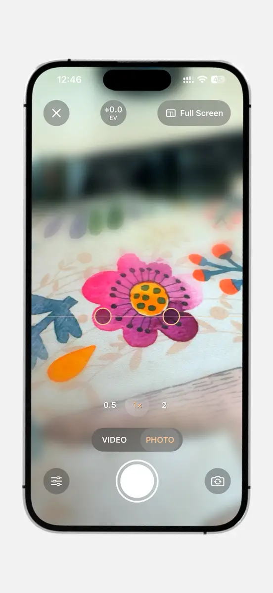 Full screen photo mode with a flower, focus band handles, exposure value and zoom buttons