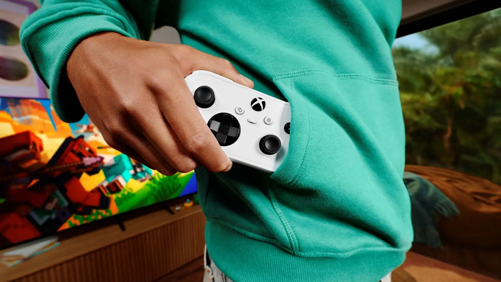 Personne glissant une petite manette XBOX blanche dans la poche d'un chandail